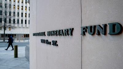 A pedestrian walks past the IMF headquarters in Washington. AFP