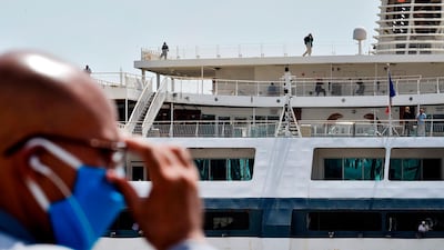 A man watches as passengers board a ship in the port of Algiers, the capital of Algeria, heading to the French port city of Marseille, in the first ferry between the two countries since the outbreak. AFP
