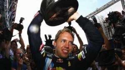 Sebastian Vettel of Red Bull Racing celebrates with teammates in the paddock after winning the British Grand Prix at Silverstone.