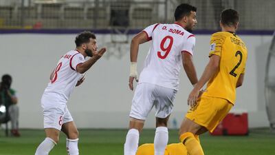 Syria's Mahmoud Al Mawas reacts to a yellow card as Australia's Aziz Behich lies on the pitch. AFP