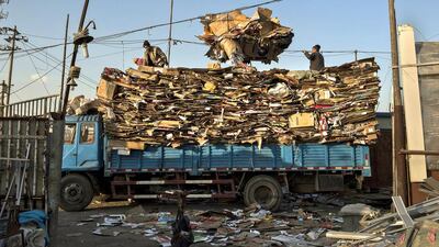 Chinese labourers load cardboard on to a truck to be recycled in the Dong Xiao Kou village. Kevin Frayer / Getty Images