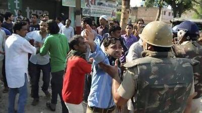 People argue with Indian policemen during curfew hours following riots and clashes between Hindus and Muslims in Muzaffarnagar, in the Indian state of Uttar Pradesh.