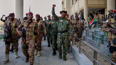 Sudan's army chief Gen Abdel Fattah Al Burhan, centre, is greeted by troops at Khartoum's presidential palace, which was recently recaptured from the Rapid Support Forces. AP