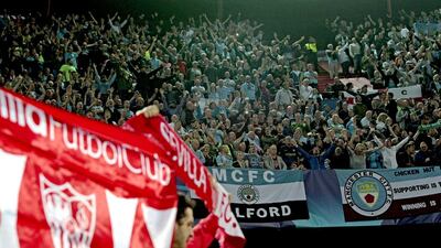 Travelling Manchester City supporters cheer on the club during their Champions League match on Tuesday at Sevilla. Julio Munoz / EPA