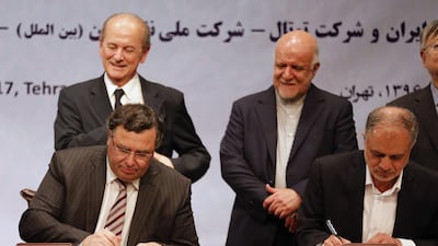 Iranian Oil Minister Bijan Namadar Zanganeh (C-R) looks on as Patrick Pouyanne (L), Chairman and CEO of French energy company Total, and Ezzatollah Akbari, Managing Director of Petropars Group, sign an offshore gas field agreement in Tehran, on July 3. Atta Kenare / AFP