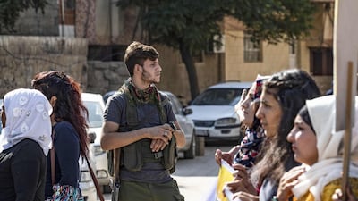 A member of the Kurdish Internal Security Force known as Asayesh stands guard during a protest against the Turkish assault on northeastern Syria, in the town of Qamishli. AFP