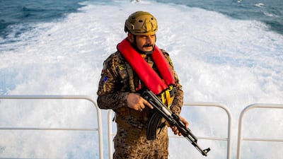An Iraqi navy marine stands guard while on duty aboard a vessel at sea in the Gulf, south of the Faw peninsula. AFP