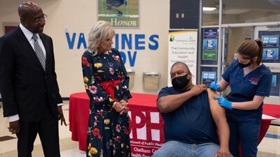 First lady Jill Biden and Mr Warnock look on as a man is vaccinated against Covid-19 in Savannah, Georgia. AP