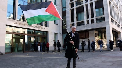 A person waves a Palestine flag outside Westminster Magistrates' Court in central London, where 28 alleged Palestine Action supporters appeared. AFP