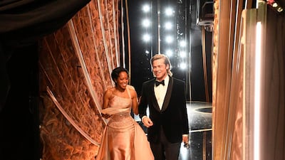 Regina King and Best Actor in a Supporting Role winner Brad Pitt walk backstage during the 92nd Oscars at the Dolby Theatre in Hollywood, California on February 9, 2020. AFP