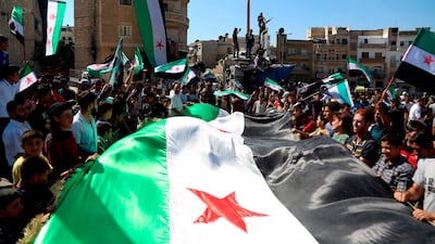 Syrian protesters, wearing the colours of opposition, attend an anti-government demonstration in the rebel-held northern Syrian city of Idlib. AFP