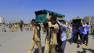 Yemeni children help carrying coffins of schoolchildren killed in an explosion near two schools in the capital Sanaa. AFP