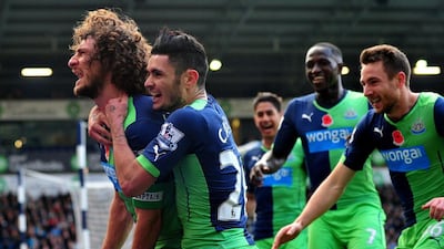 Newcastle United's Argentinian defender Fabricio Coloccini, left, celebrates scoring their second goal with his teammates in their 2-0 win over West Bromwich Albion in their English Premier League match on November 9, 2014. Paul Ellis / AFP