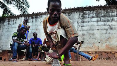A man sharpens his machete as young people, who created a self-defence committee for their district Benz-vi, meet before leaving for a patrol in their district, on March 12 in Bangui. UN investigators left for the Central African Republic on March 10 to launch a probe into human right violations in the conflict-ravaged country amid fears of genocide and ethnic cleansing. Sia Kambou / AFP