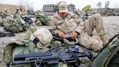 Private Larry Smith of San Fernando, California listens to music while waiting for a flight at Afghanistan's Bagram Air Base in April 2002.