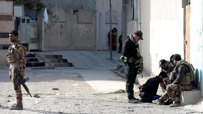 Members of an Iraqi Special forces intelligence team talk to a suspected ISIL fighter.
