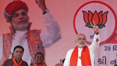 Gujarat chief minister Narendra Modi, right, flashes a victory sign during an election campaign at Viramgam in Gujarat. He is widely expected to be swept into office.