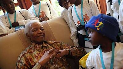 Nelson Mandela is surrounded by children at his home in Johannesburg yesterday.