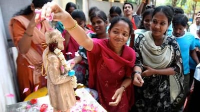 Students performing puja (worship) to the statue of Isaac Pittman, inventor of Pitman's shorthand, at the Stenographers' Guild Institute in Chennai.