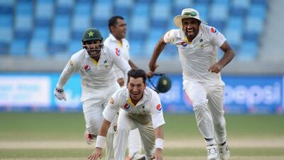 Yasir Shah of Pakistan celebrates with teammates Sarfraz Ahmed and Wahab Riaz after dismissing Adil Rashid of England to win the second Test on Monday in Dubai. Gareth Copley / Getty Images / October 26, 2015