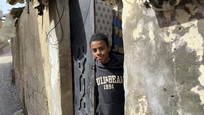 A young man looks out from his front door in Jerash refugee camp, better known as the Gaza camp, where about a third of Jordan's estimated 150,000 refugees from the Palestinian Gaza Strip live. Amy McConaghy / The National