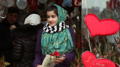 A woman holds a bouquet of roses as she leaves a flower shop in Kabul last year. AP