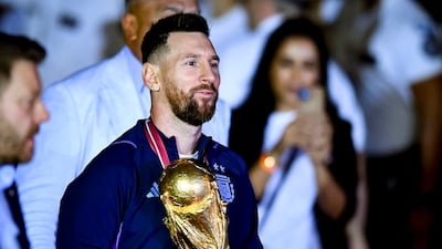 Lionel Messi with the World Cup trophy after arriving at Ezeiza International Airport. Getty