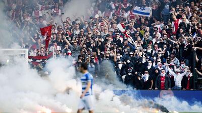Flares thrown onto the pitch by fans interrupt the Dutch Cup final match between Ajax Amsterdam and PEC Zwolle in Rotterdam. Olaf Kraak / ANP / AFP / April 20, 2014