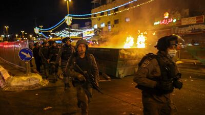 Israeli police run past a fire in the street during clashes with Palestinian protesters outside the Damascus Gate in Jerusalem's Old City on April 22, 2021. AFP