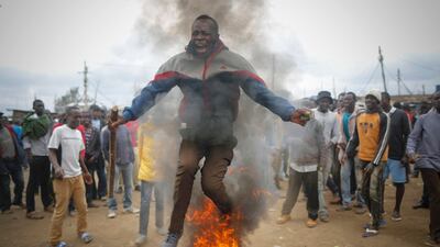 A supporter of the opposition leader Raila Odinga of the National Super Alliance (NASA) coalition jumps over a burning tyre as he and others protest after Odinga announced that he rejects the provisional result of the presidential election announced by the electoral body, in Kibera slum, one of Odinga's strongholds in Nairobi. DAI KUROKAWA / EPA