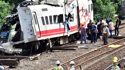Workers survey the aftermath of a train derailment in Yilan county, northeastern Taiwan. AP Photo