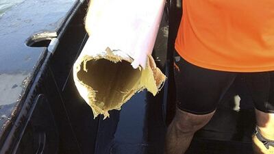 Gavin Kleidon holds a part of his damaged kayak on his right arm after a shark attack in Moreton Bay off Brisbane, Australia. Queensland Police Service via AP