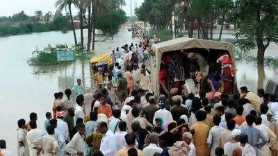 Pakistani army soldiers help flood survivors to board a truck as they evacuate the flooded area of Bassera village yesterday.