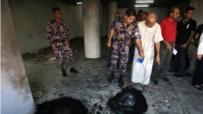 Palestinians and Palestinian security forces inspect the damage inside a mosque torched and vandalised by arsonists in the West Bank village of Qusra, near Nablus yesterday. Nasser Ishtayeh / AP Photo