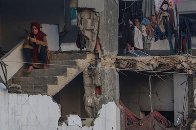 A displaced Palestinian woman sits on the stairs of a destroyed building in Gaza city. EPA