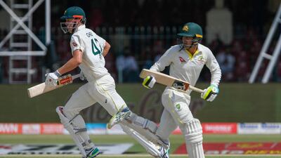 Australia's Alex Carey (R) and Cameron Green take a run during the second day of the third cricket Test match between Pakistan and Australia at the Gaddafi Cricket Stadium in Lahore on March 22, 2022. (Photo by Aamir QURESHI / AFP)