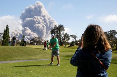 Sean Bezecny, 46, of Houston, Texas, poses for a photo as ash erupts from the Halemaumau Crater near the community of Volcano during ongoing eruptions of the Kilauea Volcano in Hawaii, May 19, 2018. Terray Sylvester / Reuters