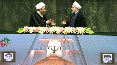 Iranian president Hassan Rouhani extends his hand to Iran's judiciary chief, Sadegh Larijani, during the swearing-in ceremony for his second term at the parliament in Tehran on August 5, 2017. Nazanin Tabatabaee Yazdi / Tima via Reuters