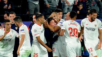 Sevilla's Argentinian midfielder Guido Pizarro, centre right, celebrates with his manager Eduardo Berizzo, centre left, after scoring the equaliser in a 3-3 draw with Liverpool in a Champions League group game. The Spanish club confirmed after the match that Berizzo had been diagnosed with cancer. Cristina Quicler / AFP