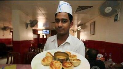 Alamgir Hossain, an employee at Kathmandu Highland restaurant in Bur Dubai, holding a plate of chicken dumplings.