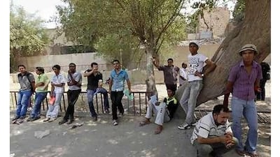 The day after: Iraqi recruits gather near the military headquarters in Baghdad where a suicide attack on Tuesday killed 61 people.
