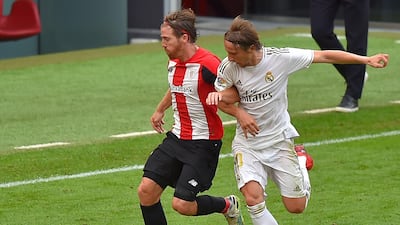 Real Madrid midfielder Luka Modric challenges Athletic Bilbao forward Iker Muniain. AFP