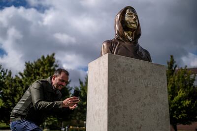 A passerby takes a photo of a Satoshi Nakamoto statue in Budapest, Hungary. The statue's creators, Reka Gergely and Tamas Gilly, used anonymised facial features as Nakamoto's true identify remains unconfirmed. Getty