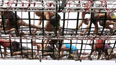 Competitors navigate their way through a rope obstacle.