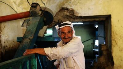 A farmer prepares his olives to crush at a traditional stone press.