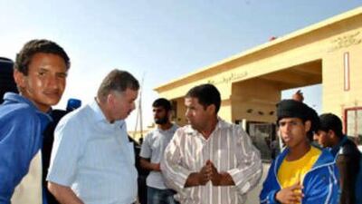 Mohammed Badie, second from left, negotiates with men who helped carry his luggage after he crossed over to Egypt from Gaza at the newly opened Rafah border crossing.