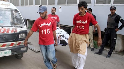 Rescue workers move the body of one of four militants killed in a shootout in Karachi on September 4, 2017. Shahzaib Akber / EPA
