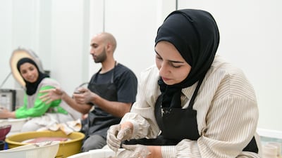 Al Hosani with her friends creating pieces using the process of wheel throwing.