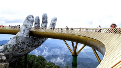 Visitors walk along the 150-meter long Cau Vang Golden Bridge in the Ba Na Hills near Da Nang, Vietnam. AFP