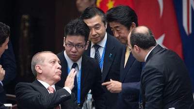 Turkey's president Recep Tayyip Erdogan, left, and Japanese prime minister Shinzo Abe, second from right, talk before the start of the G20 summit in Hangzhou, China. Mark Schiefelbein / AFP